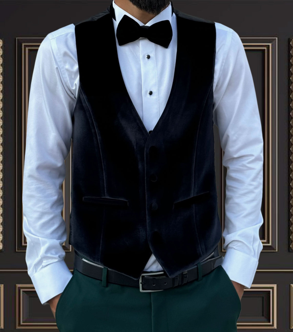 Men's black velvet vest with bow tie, worn over a white shirt, perfect for formal events and tuxedo ensembles.